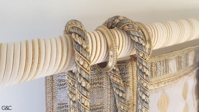 La tringle à rideaux disparait derrière la passementere dans les tons beige blanc cassé