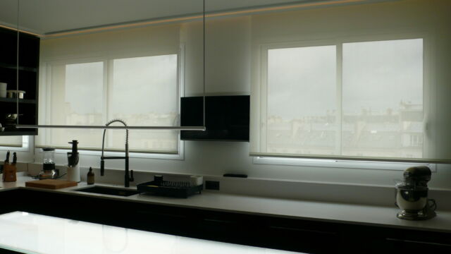 Cuisine très moderne décorée en noir et blanc avec stores enrouleurs télécommandés