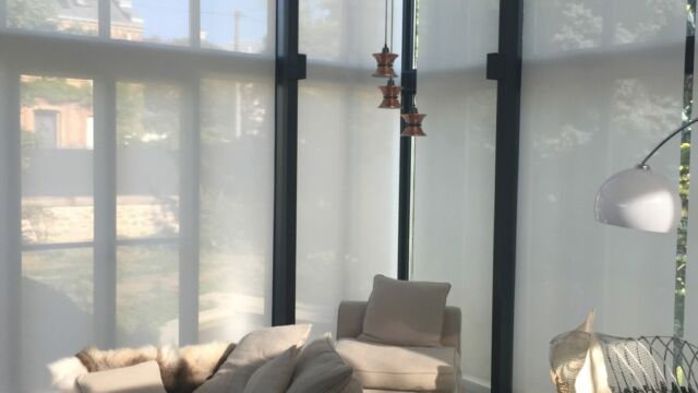 Lumineux séjour dans une véranda avec des stores enrouleurs grandes hauteur télécommandés