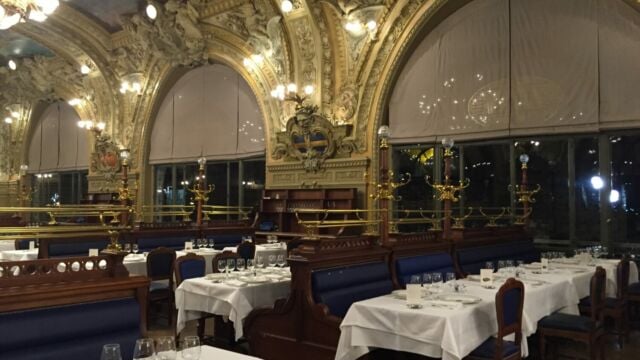 Vue d’ensemble de la salle de la brasserie le train bleu à Paris avec des stores bateaux grandes dimensions