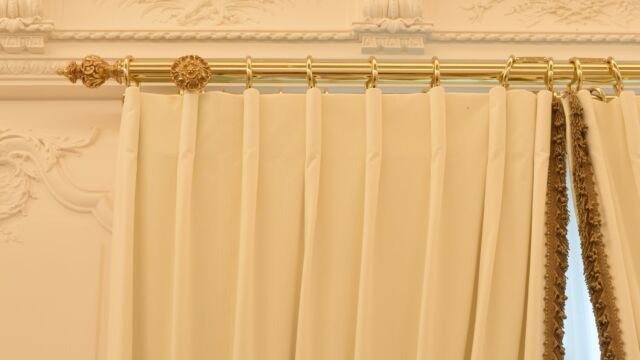 Tringle à rideaux télécommandée sur mesure finition dorure avec embouts et rosaces style Louis XV