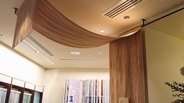 Dans le showroom Manuel Canovas Tringles coudées noires mat supports pose plafond